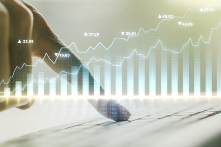 Double exposure of abstract creative financial chart with hand typing on computer keyboard on...