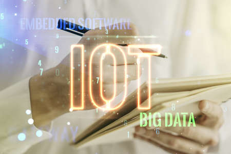 Creative IOT concept with man hand writing in notebook on background. Multiexposureの写真素材