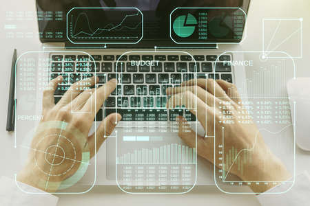 Double exposure of abstract creative statistics data hologram with hands typing on laptop on background, analytics and forecasting conceptの写真素材