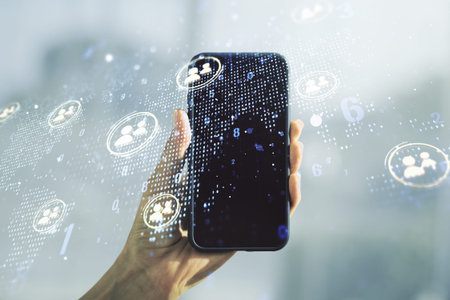 Double exposure of social network icons concept with world map and hand with cell phone on...