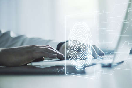 Double exposure of abstract creative fingerprint hologram with hands typing on laptop on background, research and development conceptの写真素材