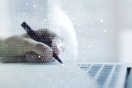 Double exposure of abstract digital world map and hand writing in notepad on background with laptop, big data and blockchain conceptの写真素材