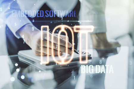 Creative IOT hologram with man hand writing in notepad on background, internet of things concept....