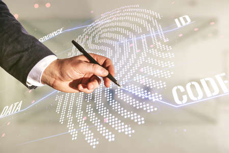 Man hand with pen working with abstract virtual fingerprint hologram on blurred office background. Multiexposureの写真素材