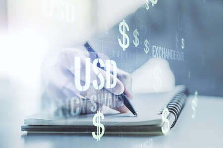 Creative concept of USD symbols illustration and man hand writing in notebook on background. Trading and currency concept. Multiexposureの写真素材