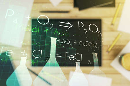 Creative chemistry illustration and modern digital tablet on desktop on background, top view, science and research concept. Multiexposureの写真素材