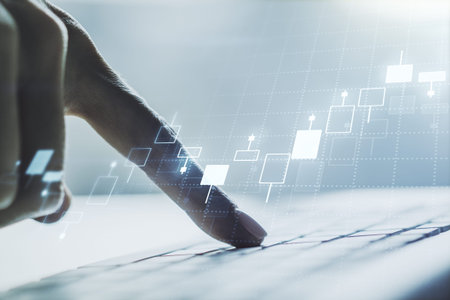 Abstract creative financial graph with hand typing on laptop on background, forex and investment...