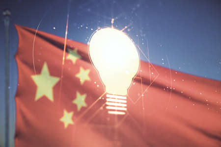 Abstract virtual light bulb hologram on flag of China and blue sky background, idea concept. Multiexposureの写真素材