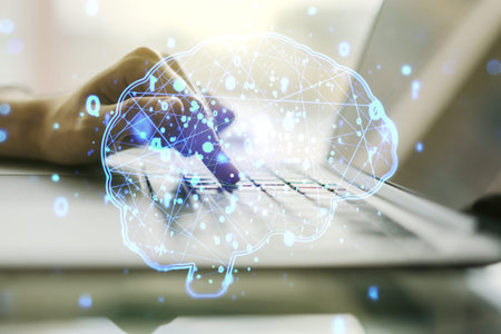Creative artificial Intelligence concept with human brain hologram and hands typing on laptop on...