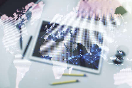 Abstract creative world map and modern digital tablet on background, top view, international trading concept. Multiexposureの写真素材