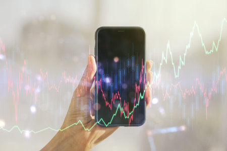 Abstract creative financial graph and hand with phone on background, forex and investment concept....