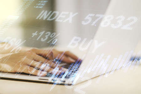Multi exposure of abstract creative financial graph with hand typing on laptop on background, forex and investment conceptの写真素材