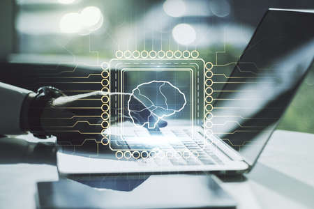 Creative artificial Intelligence concept with human brain hologram and hands typing on laptop on background. Multiexposureの写真素材