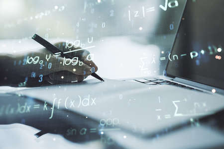 Creative scientific formula concept with hand writing in notebook on background with laptop. Multiexposureの写真素材