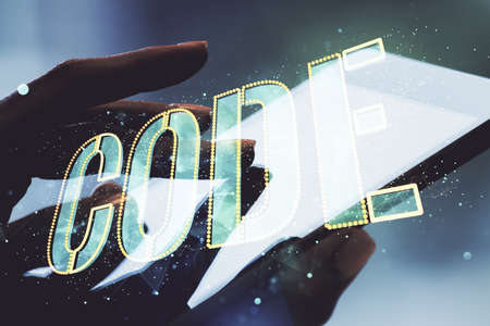Creative Code word sign and finger clicks on a digital tablet on background, international software development concept. Multiexposureの写真素材