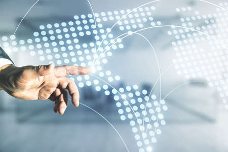 Man hand working with abstract virtual world map with connections on blurred office background, international trading concept. Multiexposureの写真素材