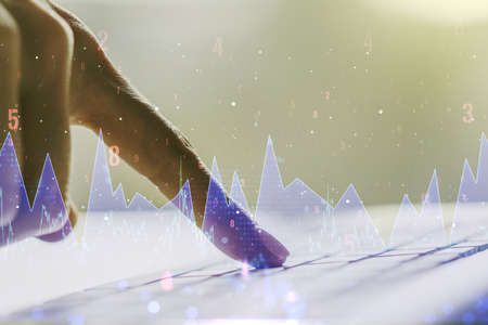 Double exposure of abstract creative statistics data hologram with hands typing on laptop on background, analytics and forecasting conceptの写真素材