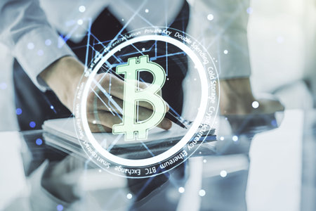 Double exposure of creative Bitcoin symbol with man hand writing in notebook on background....