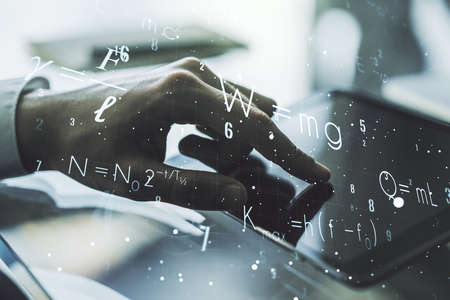 Creative scientific formula illustration with finger presses on a digital tablet on background, science and research concept. Multiexposureの写真素材