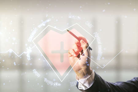 Man hand with pen draws abstract virtual heart pulse hologram on blurred interior background, online medical consulting concept. Multiexposureの写真素材