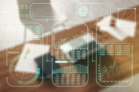 Double exposure of abstract creative statistics data hologram and modern desktop with laptop on...