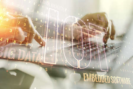 Double exposure of creative IOT hologram with hands typing on laptop on background, research and development conceptの写真素材