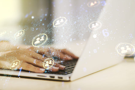 Double exposure of social network icons concept with world map and hand typing on computer keyboard...