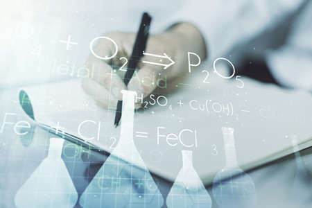 Creative chemistry concept with man hand writing in notebook on background. Multiexposureの写真素材