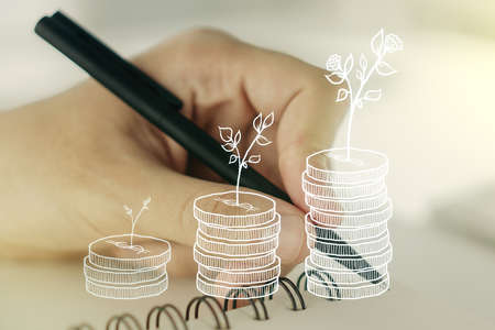 Double exposure of cash savings hologram and man hand writing in notebook on background. Development and achievement of goals conceptの写真素材