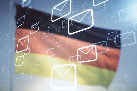 Double exposure of abstract virtual postal envelopes hologram on German flag and blue sky background. Electronic mail and spam conceptの写真素材