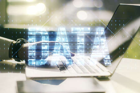 Creative Data word hologram and hands typing on computer keyboard on background, big data and blockchain concept. Multiexposureの写真素材