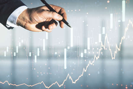 Man hand with pen working with abstract virtual financial graph on blurred office background, financial and trading concept. Multiexposureの写真素材