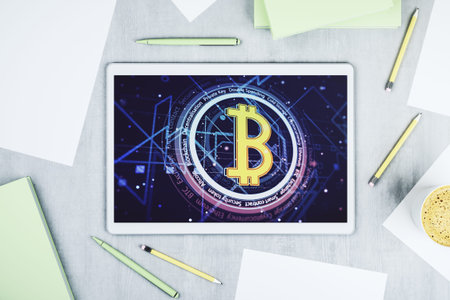Top view of modern digital tablet screen with creative Bitcoin symbol hologram. Mining and...
