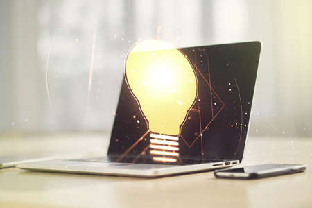 Creative light bulb hologram on modern laptop background, idea concept. Multiexposureの写真素材