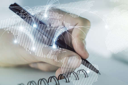 Double exposure of abstract digital world map with connections and man hand writing in notebook on background, research and strategy conceptの写真素材