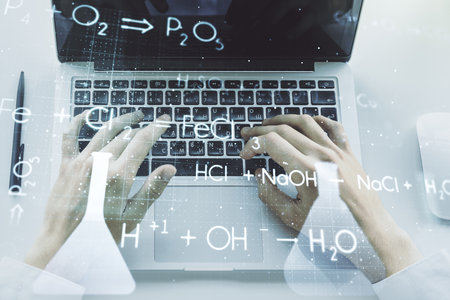 Double exposure of creative chemistry concept with hands typing on laptop on background, research and development conceptの写真素材