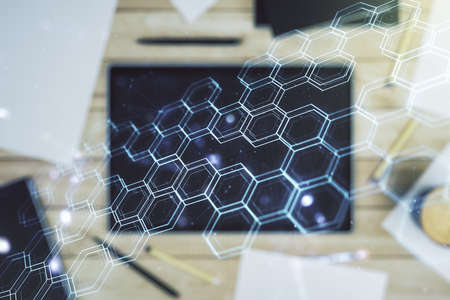 Creative concept of wireless technology with hexagon hologram and modern digital tablet on background, top view. Big data and database concept. Multiexposureの写真素材