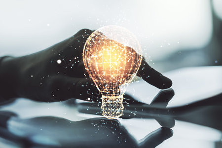 Creative light bulb hologram and hand working with a digital tablet on background, idea concept....