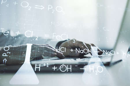 Double exposure of creative chemistry concept with hands typing on laptop on background, research and development conceptの写真素材