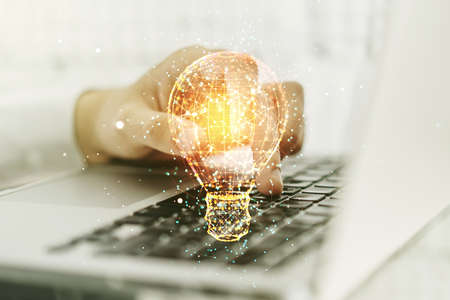 Creative light bulb illustration with hands typing on computer keyboard on background, future technology concept. Multiexposureの写真素材