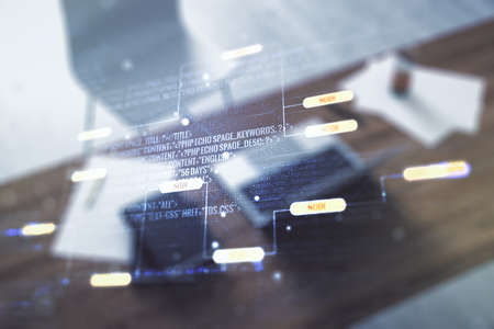 Double exposure of abstract programming language and modern desktop with laptop on background, research and development conceptの写真素材