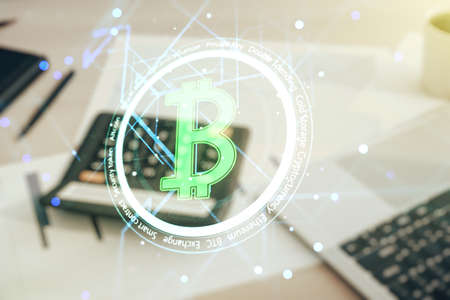 Double exposure of creative Bitcoin symbol hologram on blurry calculator with laptop background. Cryptocurrency conceptの写真素材