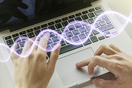 Double exposure of creative DNA hologram and hands typing on laptop on background. Bio Engineering and DNA Research conceptの写真素材