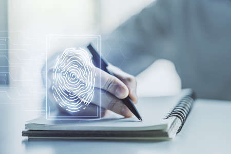 Abstract creative fingerprint concept with man hand writing in notebook on background. Multiexposureの写真素材