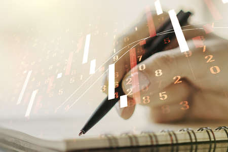 Multi exposure of abstract financial graph with hand writing in notebook on background, financial and trading conceptの写真素材