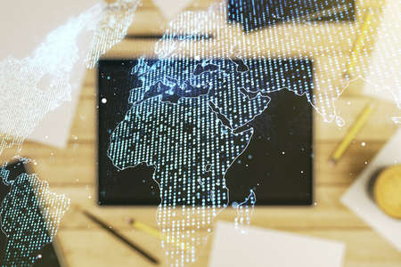 Multi exposure of abstract creative digital world map and digital tablet on background, top view, research and analytics conceptの写真素材