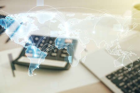 Abstract graphic digital world map hologram with connections on blurry calculator and computer background, globalization concept. Multiexposureの写真素材