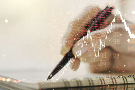 Double exposure of abstract creative financial diagram with world map and with woman hand writing in notepad on background, banking and accounting conceptの写真素材