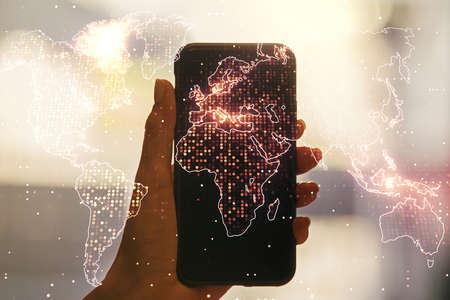 Multi exposure of abstract graphic world map and hand with mobile phone on background, big data and networking conceptの写真素材