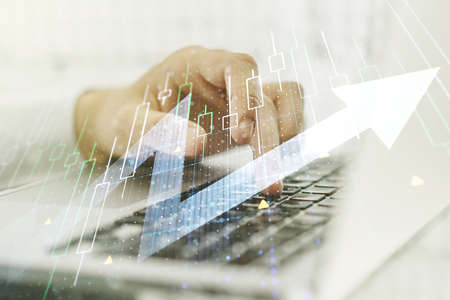 Multi exposure of abstract financial diagram with upward arrow and hand typing on laptop on background, rise and breakthrough conceptの写真素材
